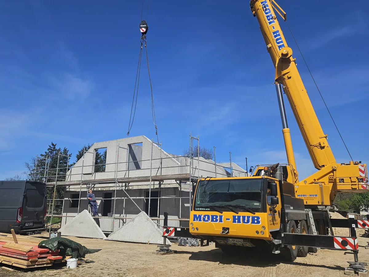 Shell construction with gable, a mobile crane in front of it